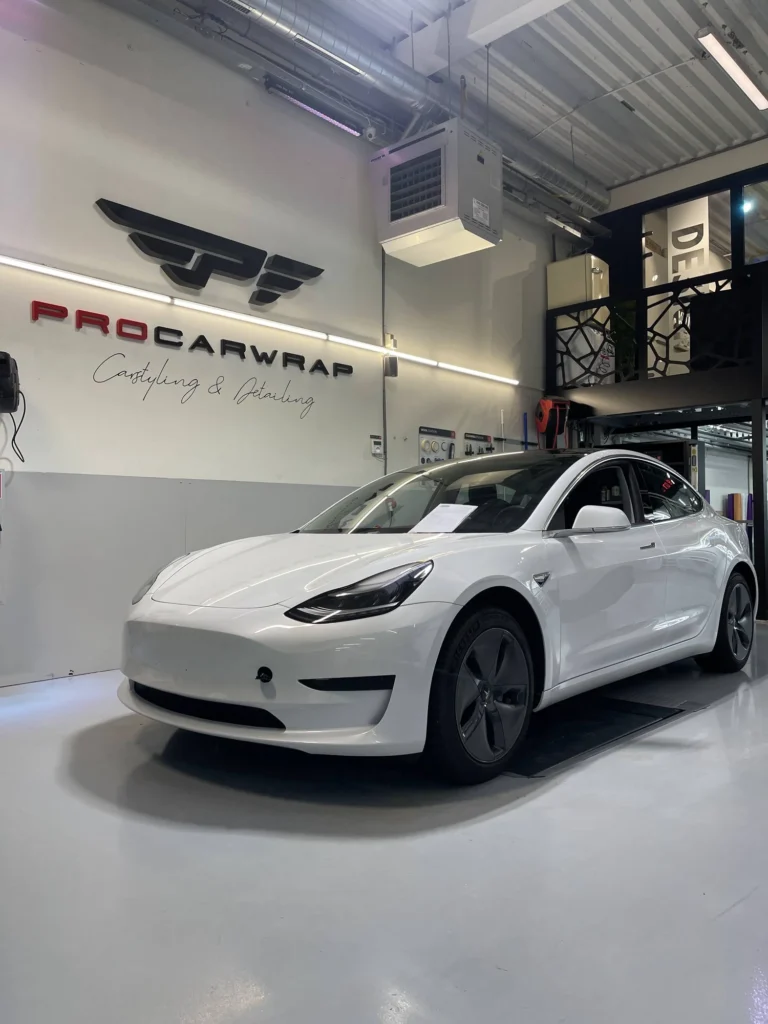 Witte Tesla met getinte achterruiten in de werkplaats