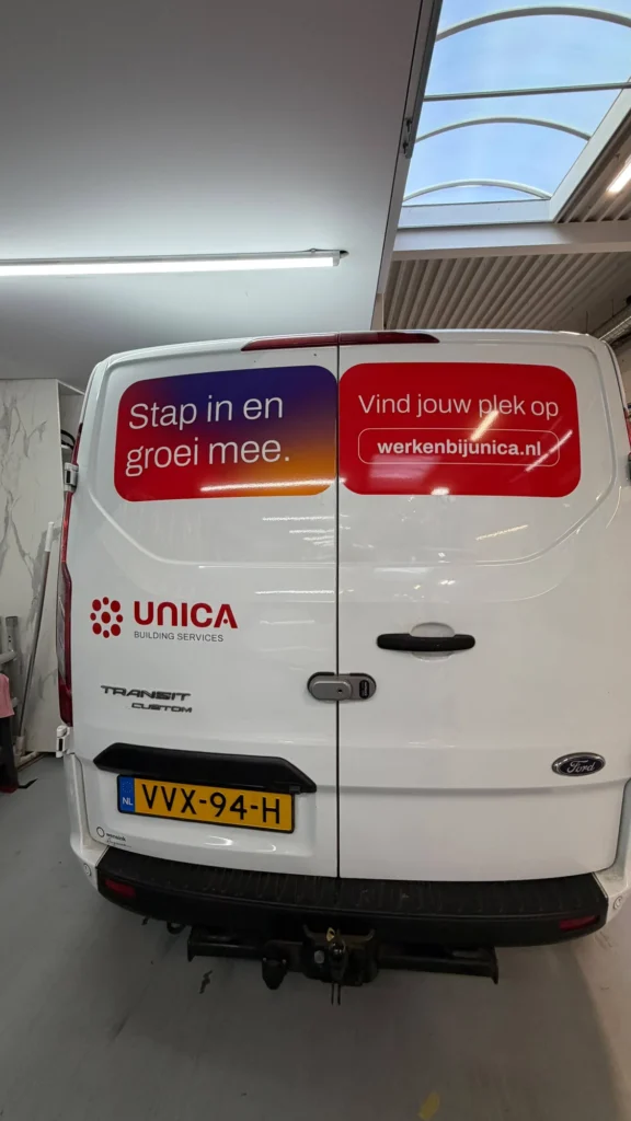 Achterzijde van een Unica bestelbus met belettering